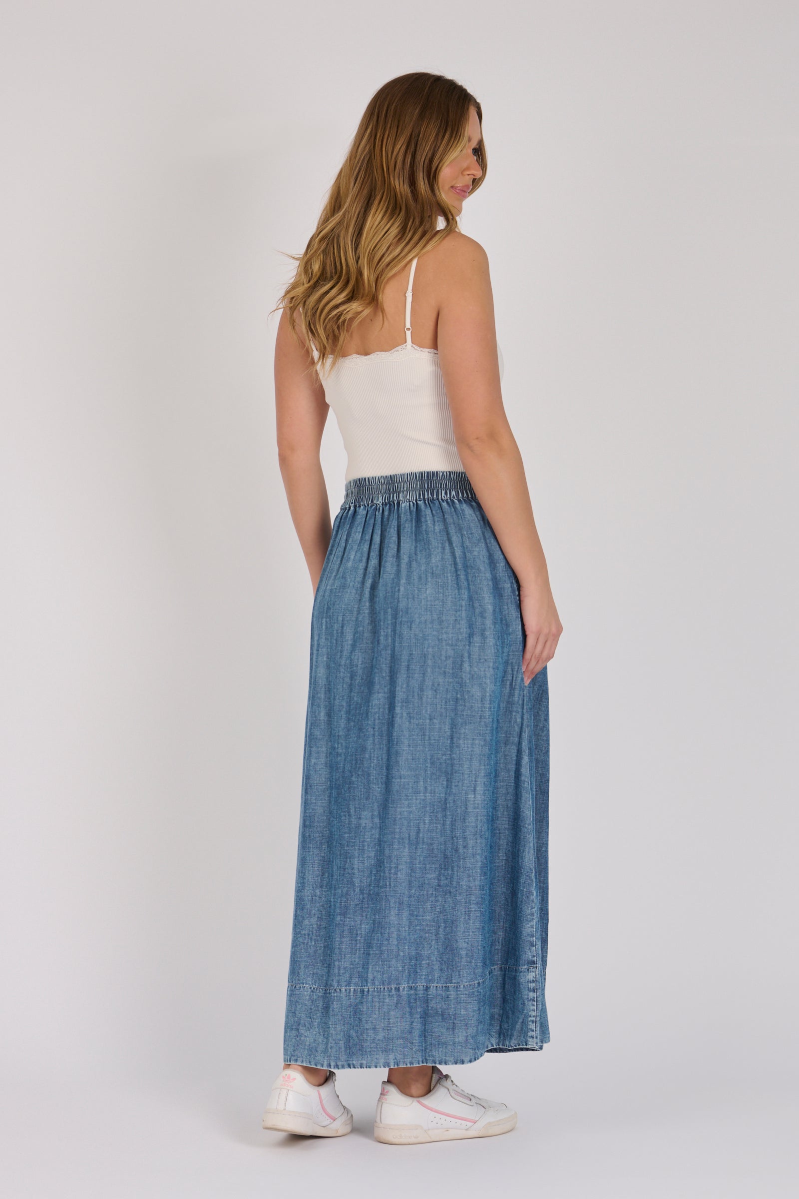 Full-length view of a dark blue lyocell midi skirt with pintuck detailing and A-line silhouette.