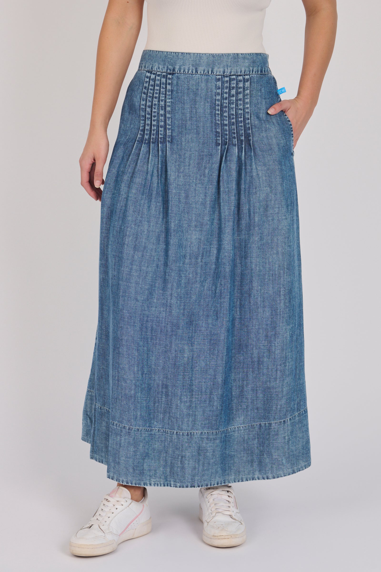 Full-length view of a dark blue lyocell midi skirt with pintuck detailing and A-line silhouette.