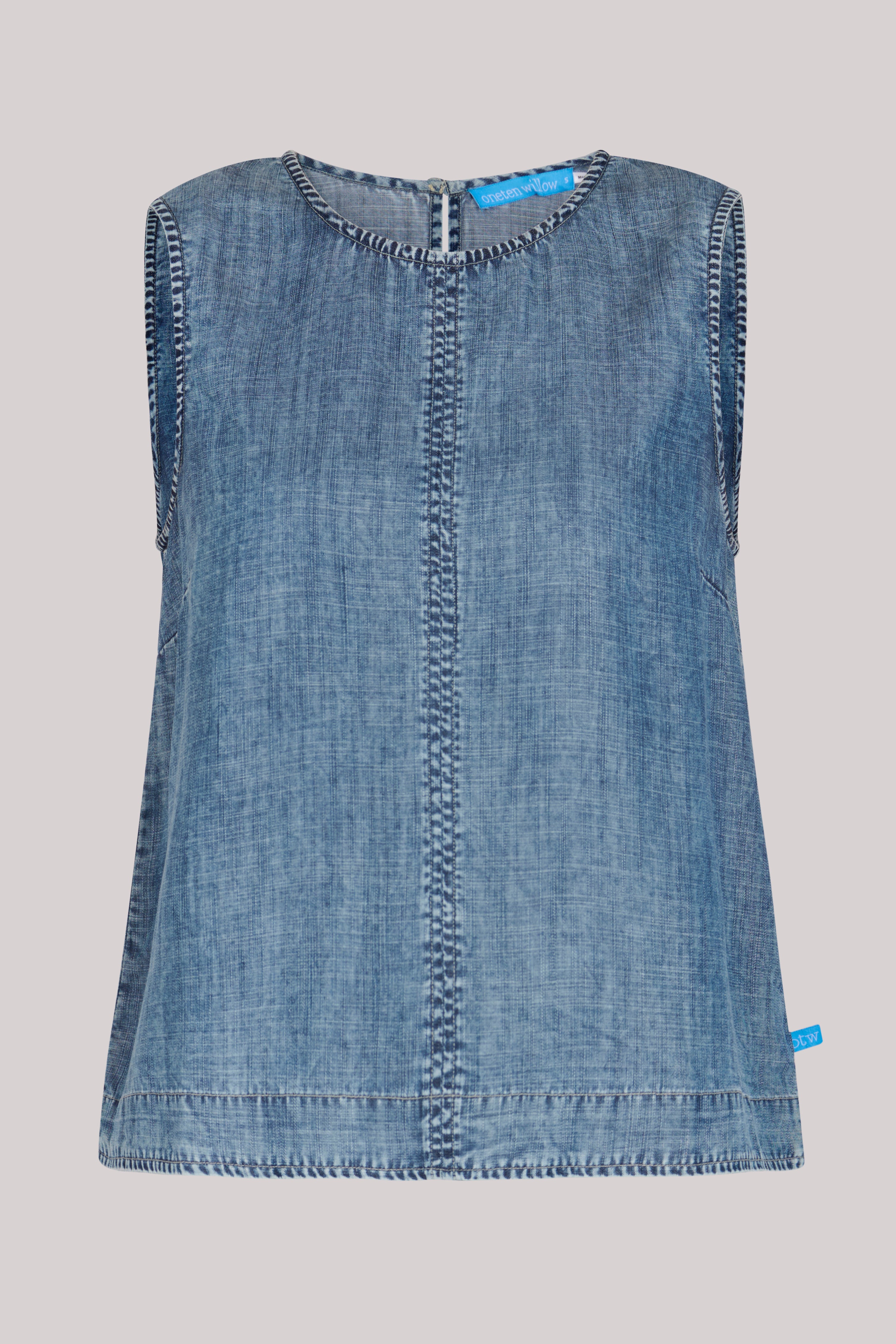 Model wearing a dark blue 100% lyocell swing top with contrast seam detailing.