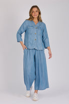 Woman wearing a light blue 100% lyocell utility jacket with patch pockets and a collarless neckline.