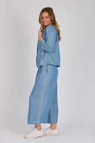 Woman wearing a light blue 100% lyocell utility jacket with patch pockets and a collarless neckline.