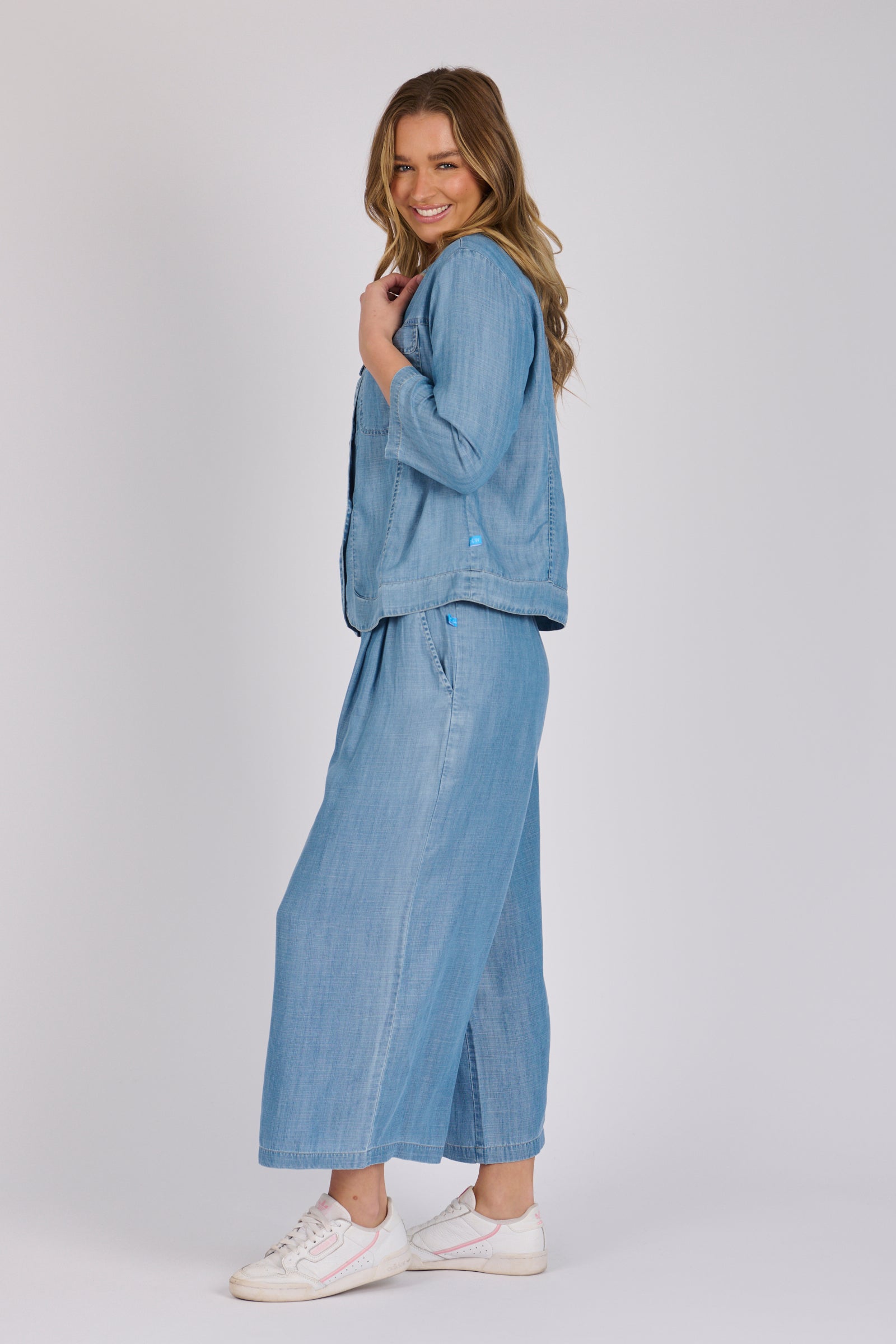 Woman wearing a light blue 100% lyocell utility jacket with patch pockets and a collarless neckline.