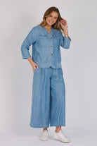 Woman wearing a light blue 100% lyocell utility jacket with patch pockets and a collarless neckline.