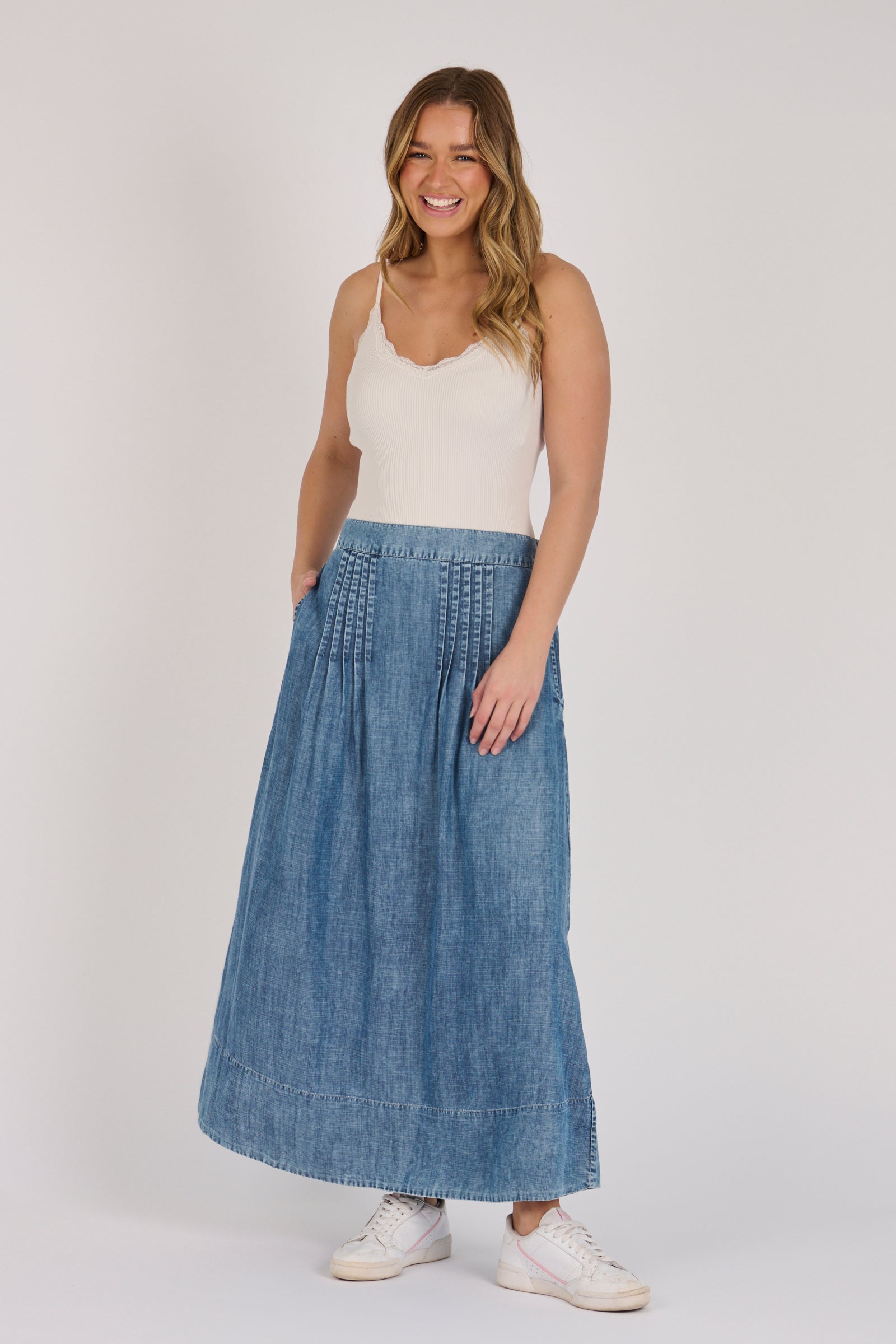 Full-length view of a dark blue lyocell midi skirt with pintuck detailing and A-line silhouette.