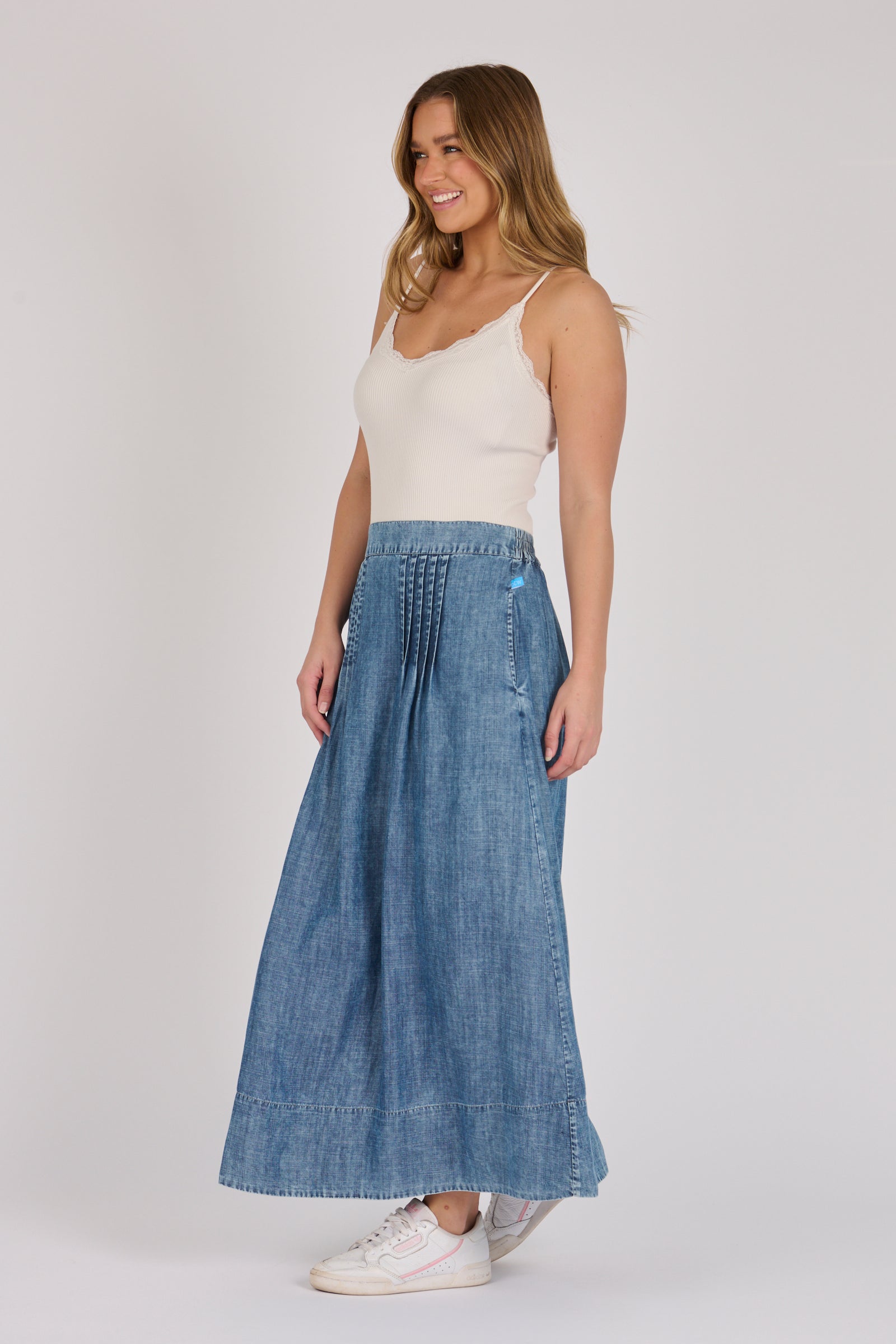 Full-length view of a dark blue lyocell midi skirt with pintuck detailing and A-line silhouette.
