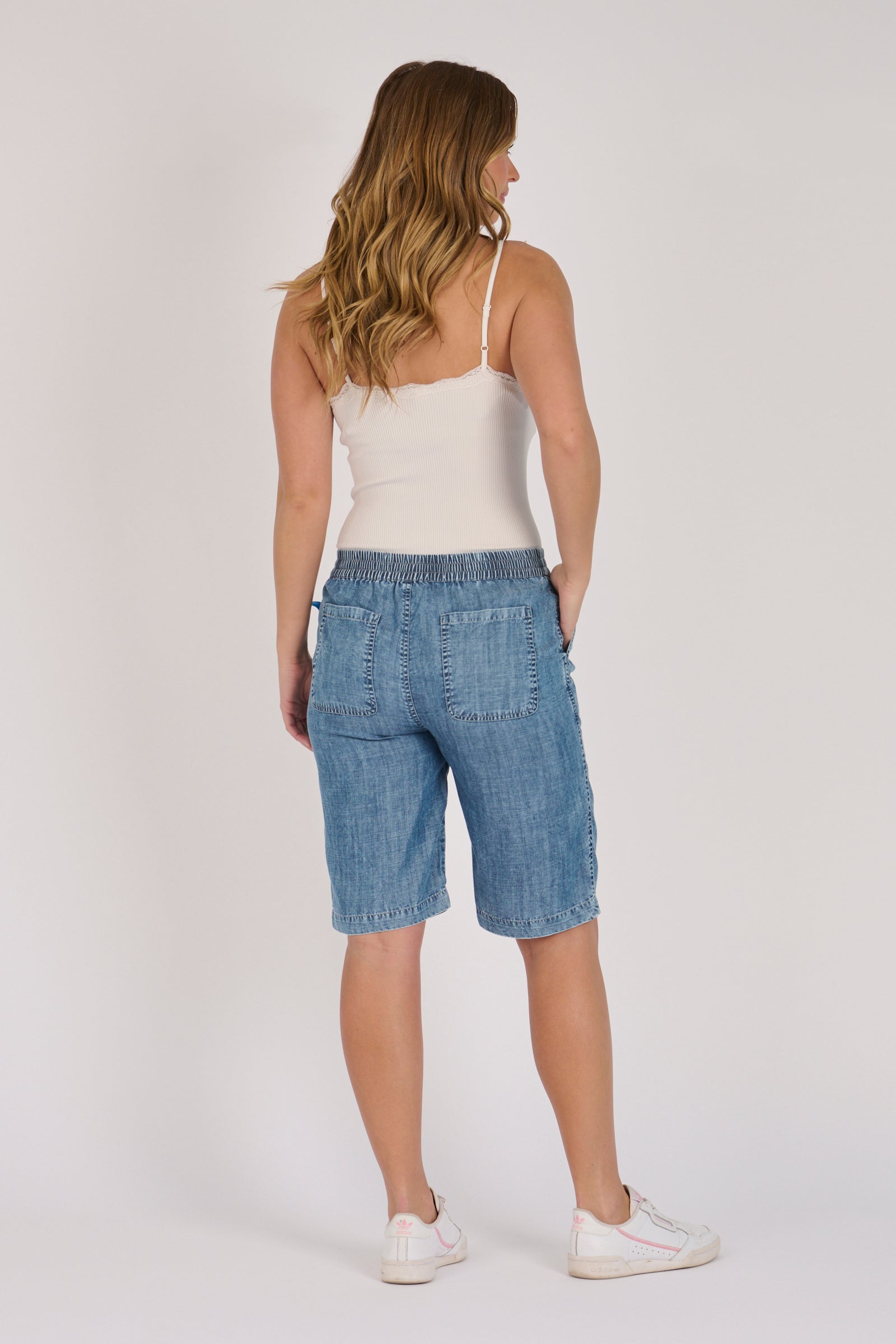Pull-On Longline Short in dark blue lyocell with knee-length cut and side pockets.
