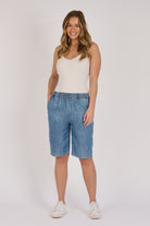 Pull-On Longline Short in dark blue lyocell with knee-length cut and side pockets.