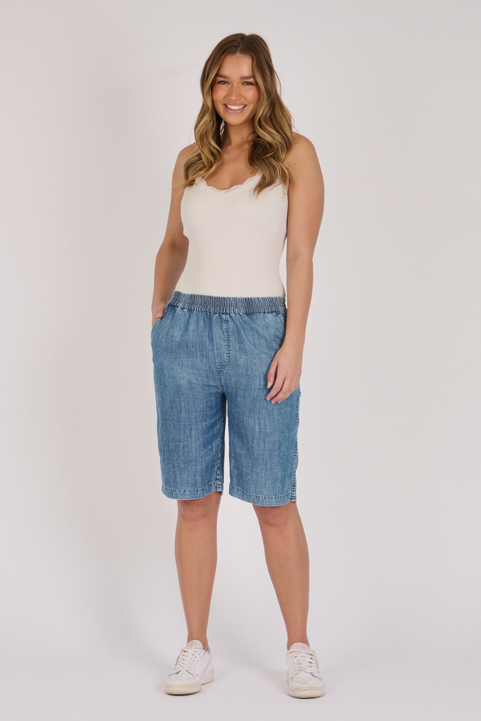 Pull-On Longline Short in dark blue lyocell with knee-length cut and side pockets.
