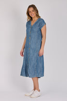 Woman wearing a dark blue 100% lyocell button-through midi dress with panelled seams and cap sleeves.