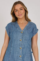 Woman wearing a dark blue 100% lyocell button-through midi dress with panelled seams and cap sleeves.