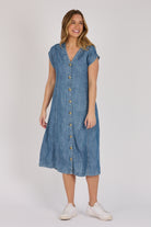 Woman wearing a dark blue 100% lyocell button-through midi dress with panelled seams and cap sleeves.