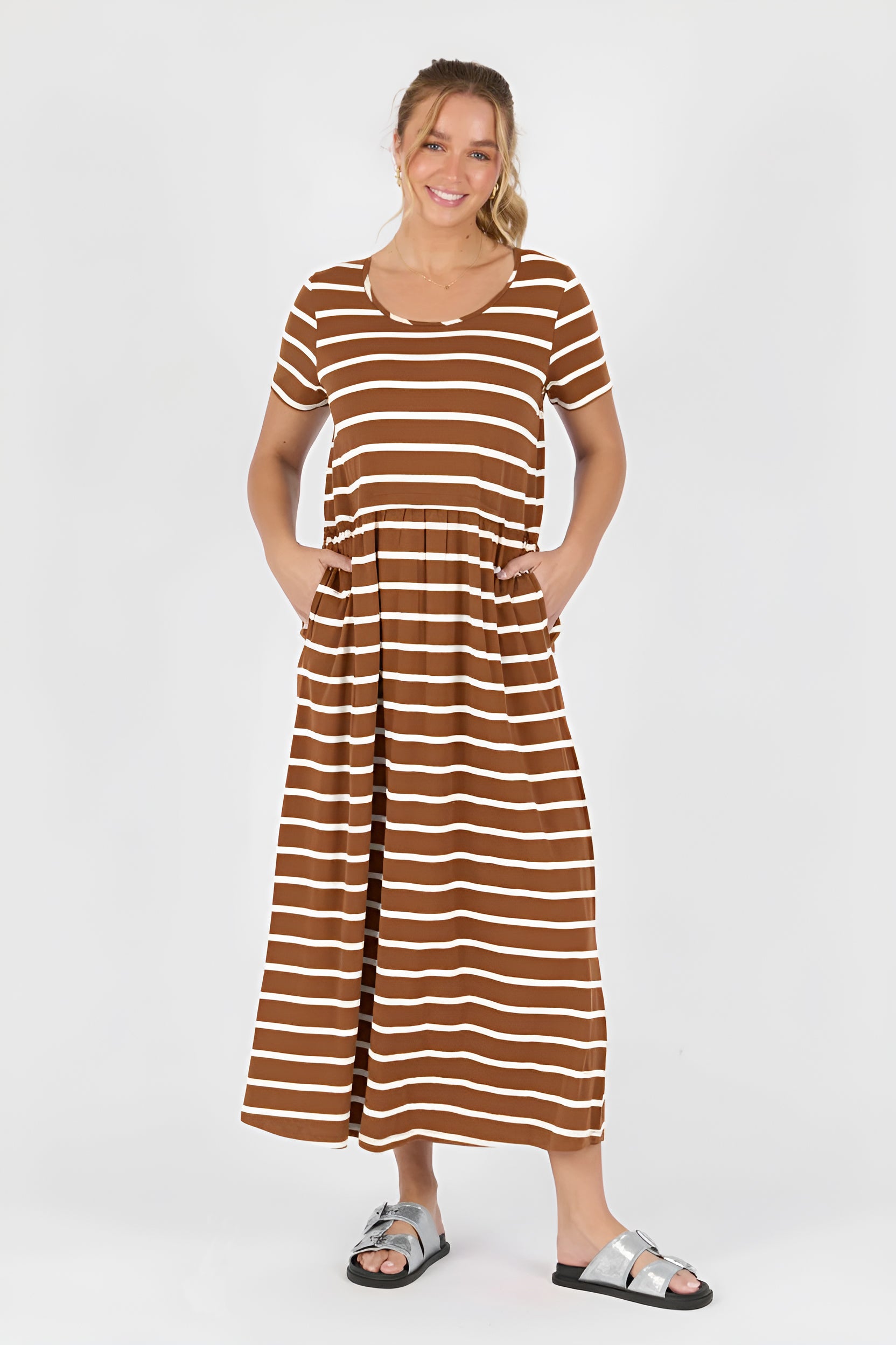 Woman wearing a acorn and white striped dress on a white background