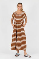 Woman wearing a acorn and white striped dress on a white background