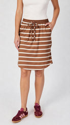 Woman wearing an acorn and white striped skirt on a white background